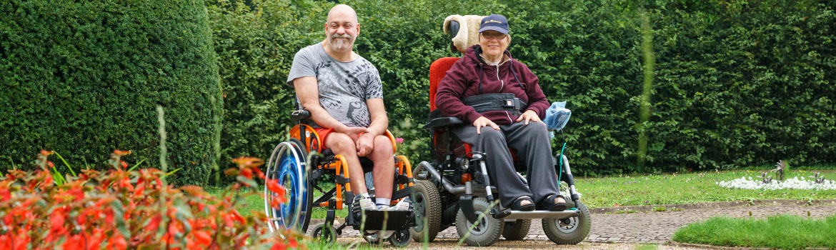 Foto von Mann und Frau in Rollstuhl in Garten